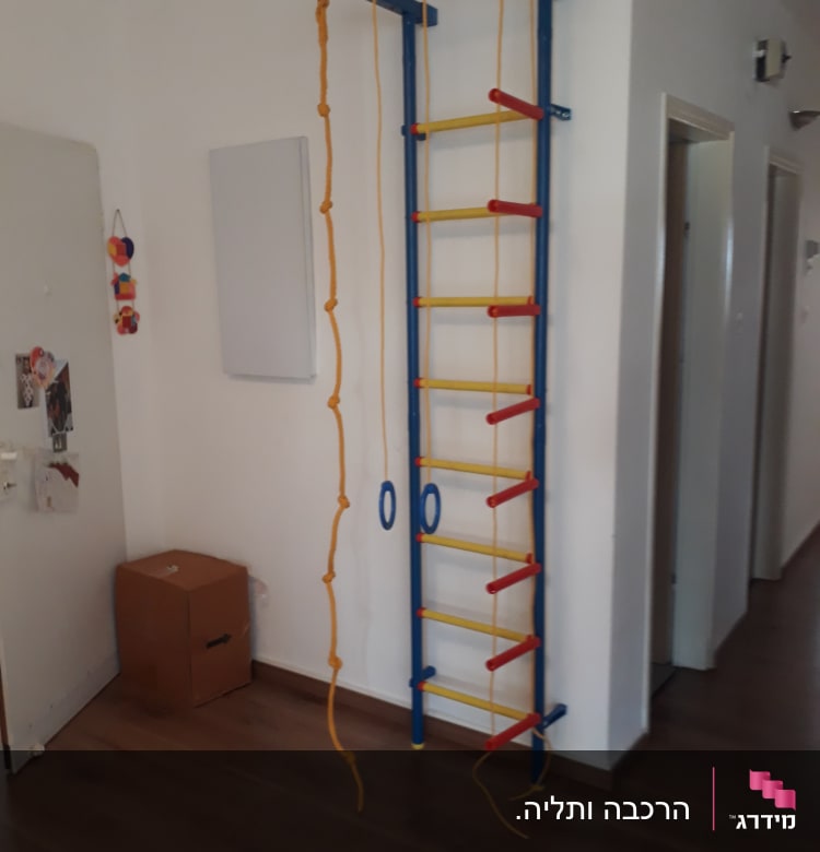 סולם טיפוס צבעוני עם חבלים על קיר